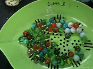 Students added marbles to their bisque-fired and glazed pinch pots, then loaded their pots into the kiln.